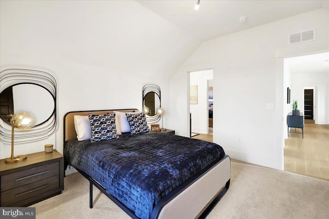 bedroom with light carpet, visible vents, and vaulted ceiling