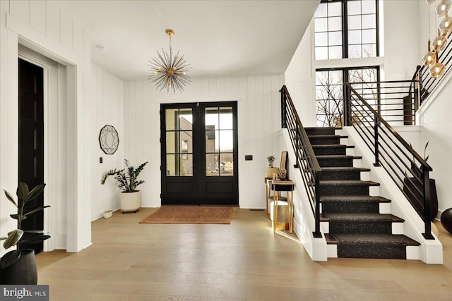 foyer entrance featuring stairs, french doors, and light wood finished floors