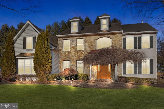 view of front of home featuring stone siding and a front lawn