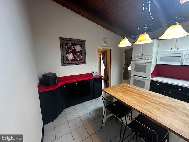 kitchen featuring pendant lighting, white appliances, dark cabinetry, and light tile patterned floors