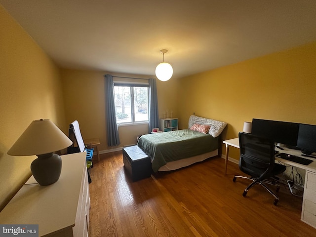 bedroom featuring baseboards and wood finished floors