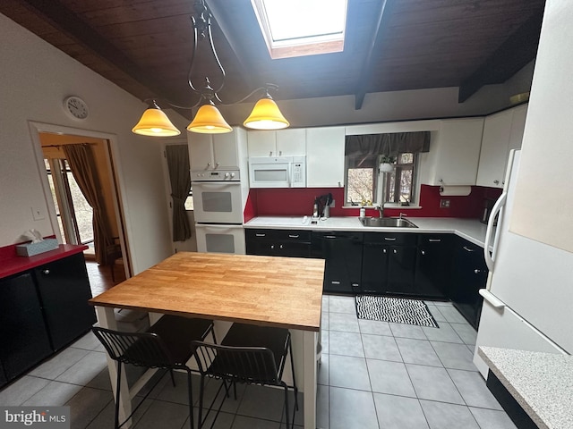 kitchen featuring white cabinets, white appliances, light countertops, and decorative light fixtures