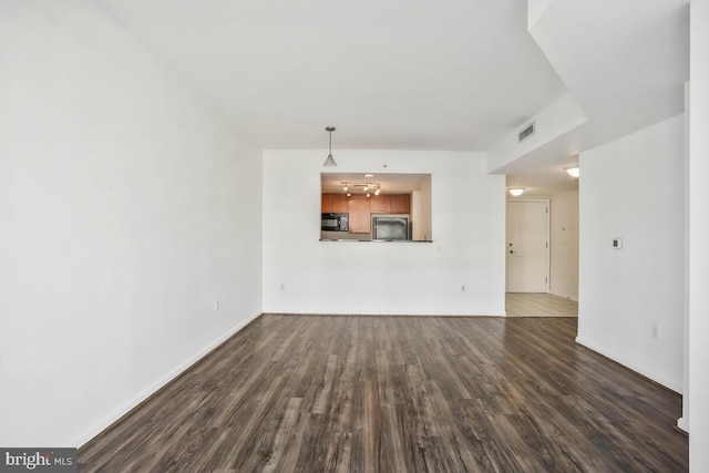 unfurnished living room with dark wood-type flooring and visible vents