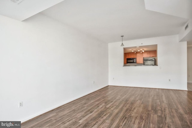 unfurnished living room with wood finished floors and visible vents