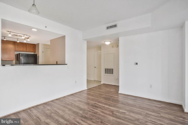 unfurnished living room featuring visible vents and light wood-style flooring