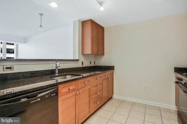 kitchen with black dishwasher, brown cabinetry, range with gas cooktop, dark stone countertops, and a sink