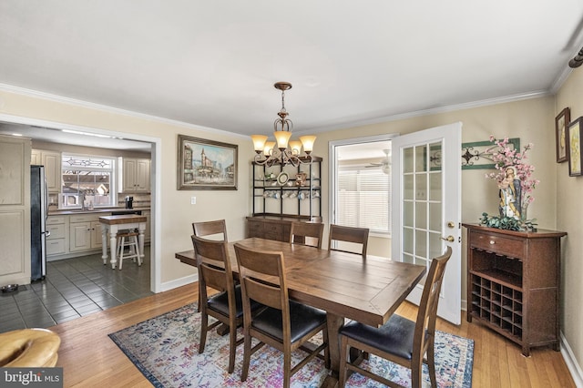 dining space featuring baseboards, ornamental molding, dark wood finished floors, and a notable chandelier