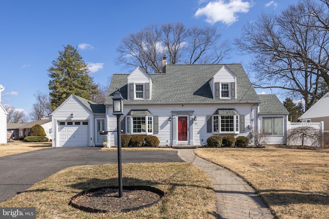 cape cod home with aphalt driveway, roof with shingles, a chimney, a front yard, and a garage