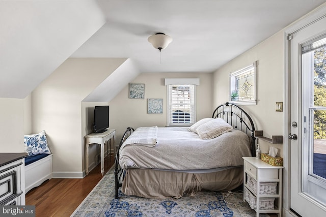 bedroom featuring vaulted ceiling, access to outside, wood finished floors, and baseboards