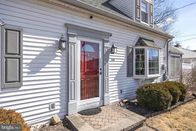 property entrance with roof with shingles