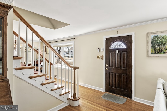 foyer featuring stairs, baseboards, and wood finished floors