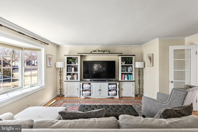 living room with baseboards, wood finished floors, and crown molding