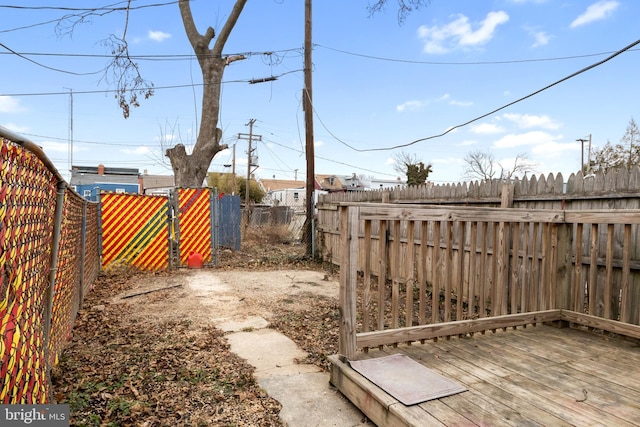 view of yard featuring a gate, a fenced backyard, and a wooden deck