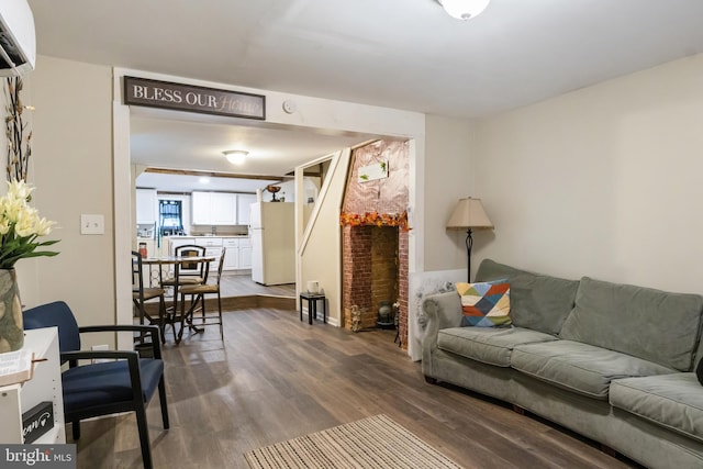 living area with dark wood-type flooring and a wall mounted air conditioner