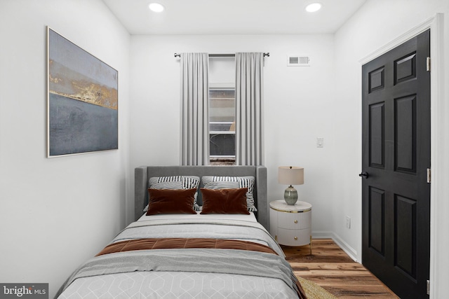 bedroom featuring recessed lighting, visible vents, baseboards, and wood finished floors