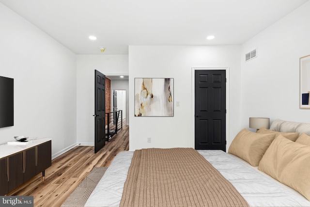 bedroom featuring baseboards, light wood finished floors, visible vents, and recessed lighting