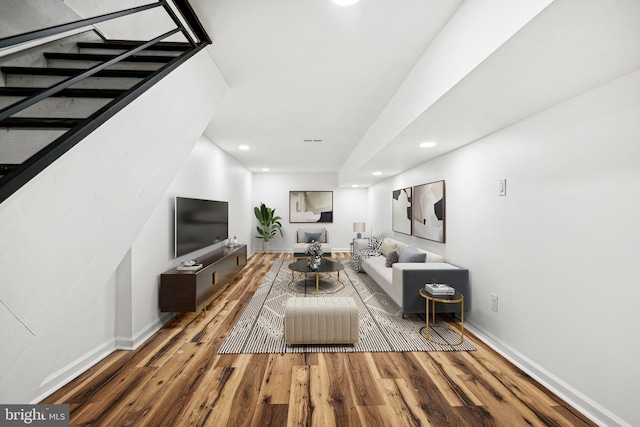 living area with stairway, baseboards, wood finished floors, and recessed lighting