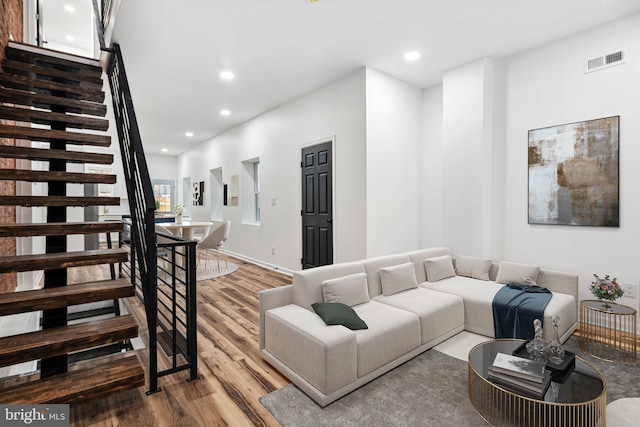 living room featuring light wood finished floors, stairway, visible vents, and recessed lighting