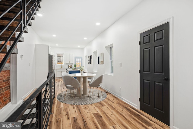 dining room featuring baseboards, light wood-style flooring, and recessed lighting