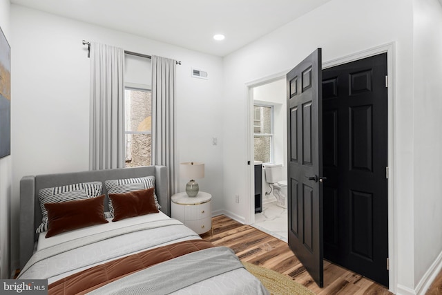 bedroom featuring baseboards, visible vents, connected bathroom, light wood-style floors, and recessed lighting