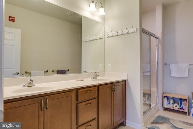 full bathroom featuring double vanity, tile patterned flooring, a sink, and a shower stall