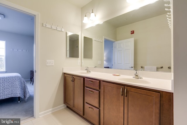 full bathroom featuring double vanity, tile patterned floors, a sink, and connected bathroom