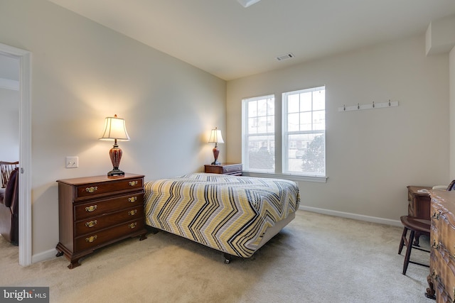 bedroom featuring baseboards, visible vents, and light colored carpet