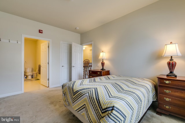 bedroom featuring ensuite bathroom, baseboards, and light colored carpet