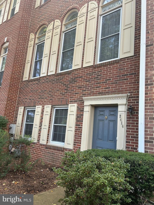 doorway to property featuring brick siding