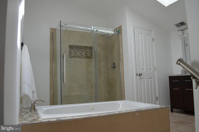 full bathroom featuring vaulted ceiling, tiled tub, a tile shower, and visible vents