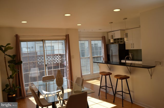 dining area with light wood-style floors and recessed lighting