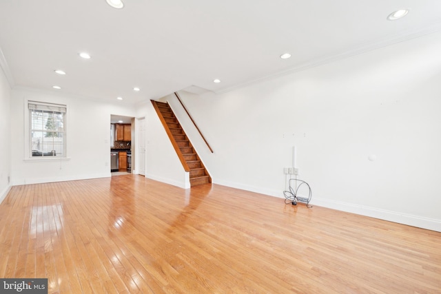 unfurnished living room with light hardwood / wood-style flooring and crown molding