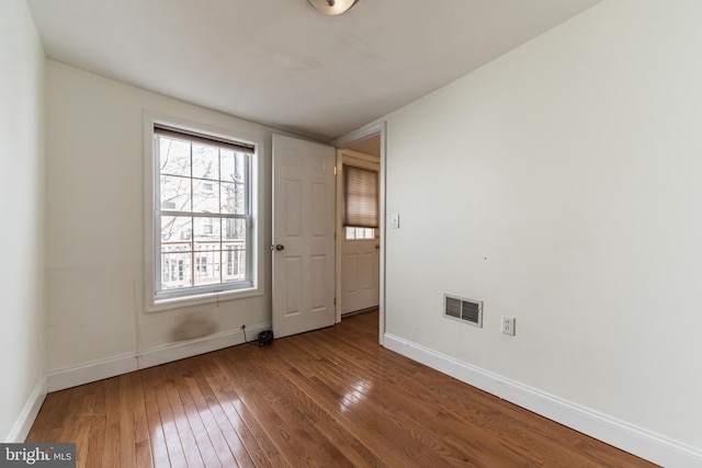 unfurnished room with hardwood / wood-style flooring