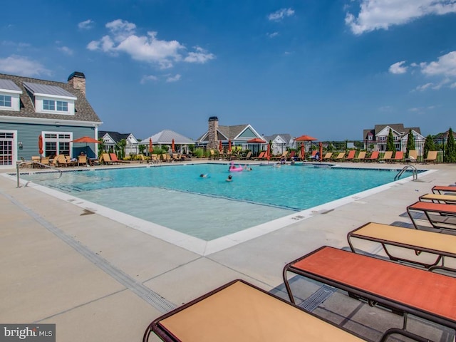 pool featuring a patio area and a residential view