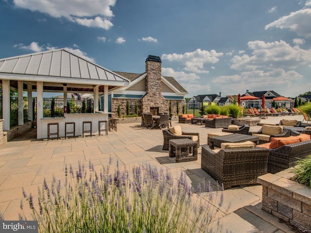 view of patio / terrace featuring a gazebo, a bar, and outdoor lounge area