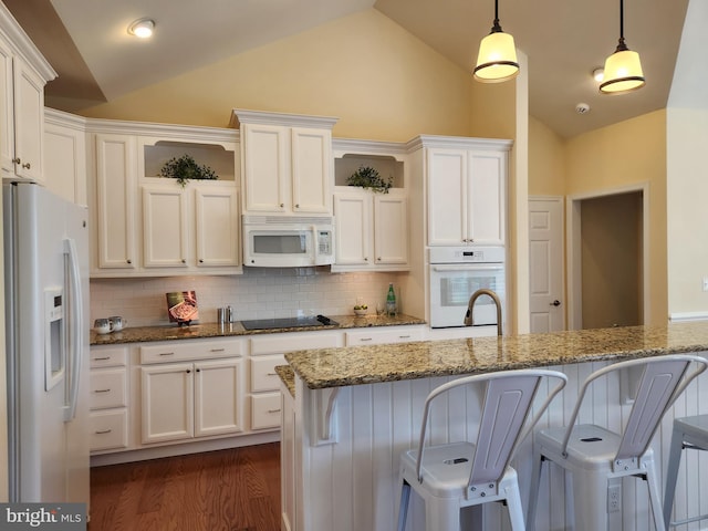 kitchen featuring pendant lighting, open shelves, light stone countertops, white appliances, and a kitchen bar