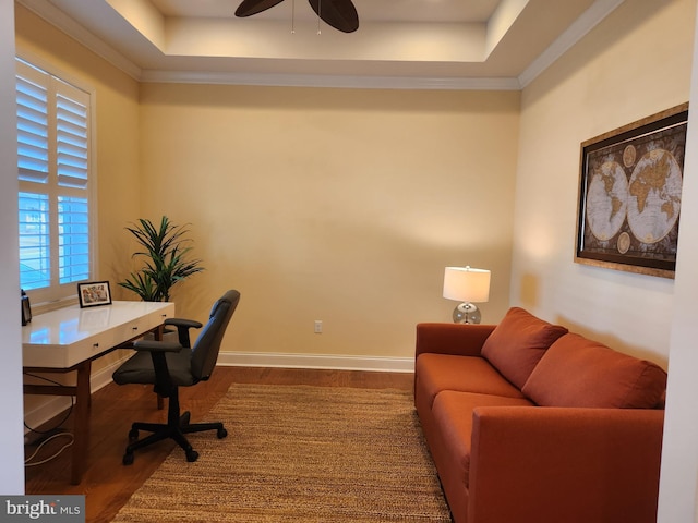 office with a ceiling fan, baseboards, a raised ceiling, and wood finished floors