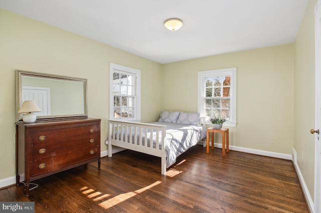 bedroom with baseboards, multiple windows, and wood finished floors