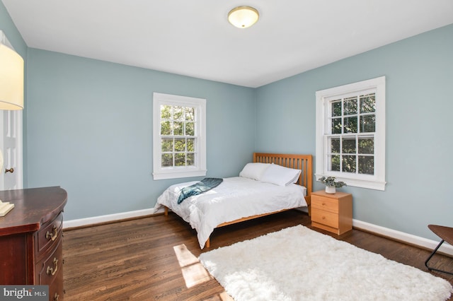 bedroom featuring baseboards and dark wood-style floors