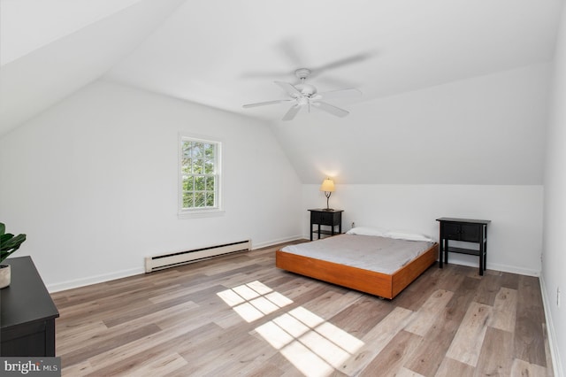 bedroom with wood finished floors, lofted ceiling, and a baseboard radiator