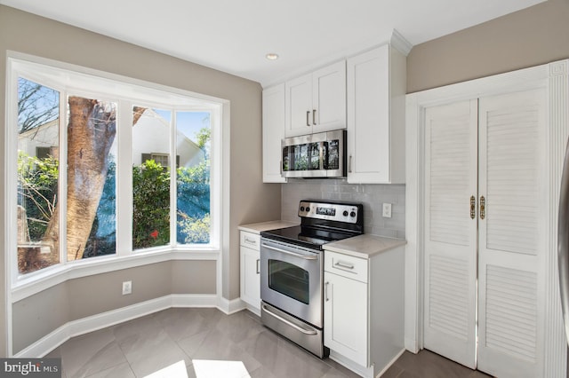 kitchen with light countertops, backsplash, a wealth of natural light, and stainless steel appliances