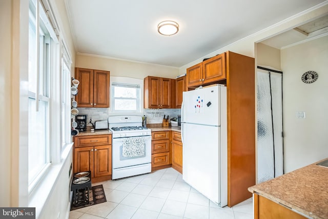 kitchen with brown cabinets, white appliances, and light countertops