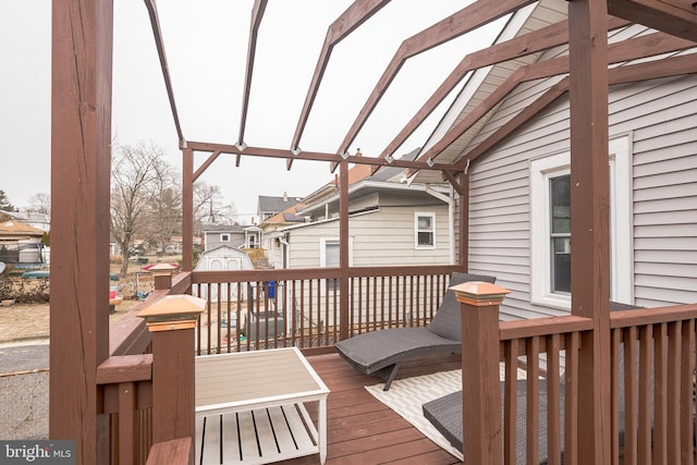 wooden terrace with an outbuilding, a residential view, and a storage unit