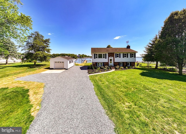 view of front facade featuring a front lawn, a garage, and an outbuilding