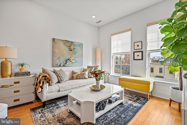 living room featuring light wood-type flooring, visible vents, and recessed lighting