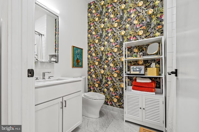 bathroom with marble finish floor, a shower with shower curtain, vanity, and toilet