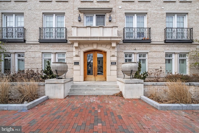 entrance to property featuring french doors and brick siding