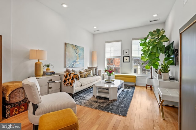 living area with light wood-style flooring and recessed lighting