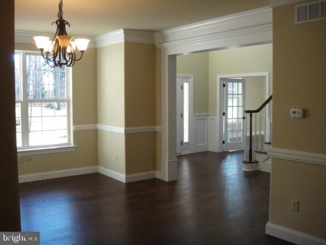 entryway featuring a notable chandelier, dark wood-type flooring, and ornamental molding