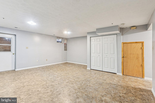 finished below grade area with a textured ceiling and baseboards